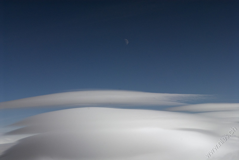 Moon above lenticular clouds