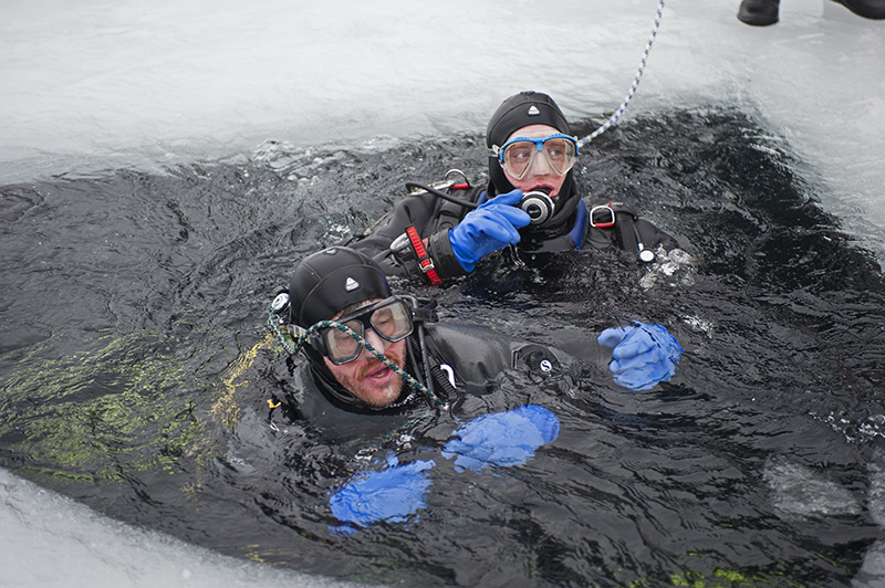 Zwei Taucher im Eisloch