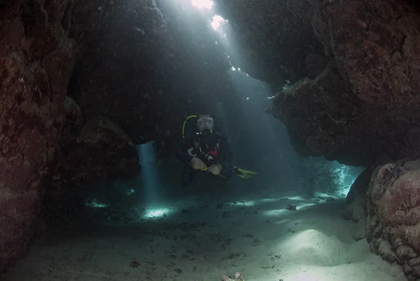 Cave Diver with Light Beams